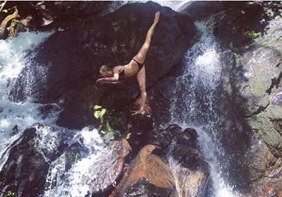 Morgan Kenny doing yoga on the steep of a waterfall