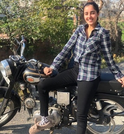 Simrat Kaur Wiki, Height, Age, Boyfriend, Family, Biography & More 17 Simrat Kaur posing infront of a bike.