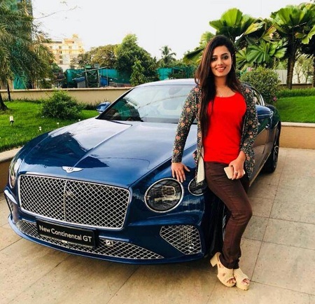 Remya Panicker poses next to a Bentley