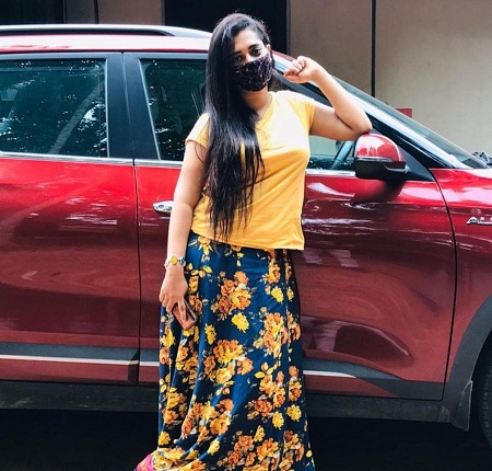 Remya Panicker stands next to her Kia Sonet